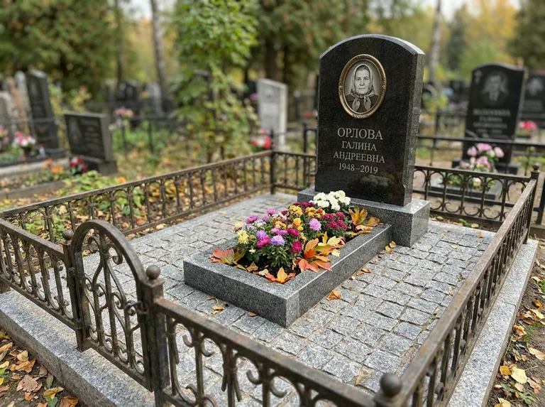 Благоустроенное захоронение с гранитной плиткой, оградой и цветником в Краснодаре