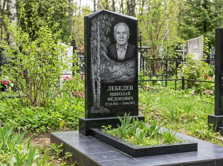 Памятник с гравировкой берёзы: вертикальная стела со скошенным верхом — берёза и стая птиц в небе, гранитный цоколь с тёмной плиткой, работа «Лебедев» в Краснодаре