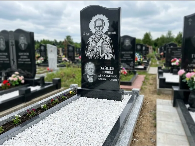 Памятник с гравировкой иконы: стела с крестообразным навершием — икона в резной рамке-киоте, газон без ограды, стриженая трава, работа «Раевская» в Краснодаре