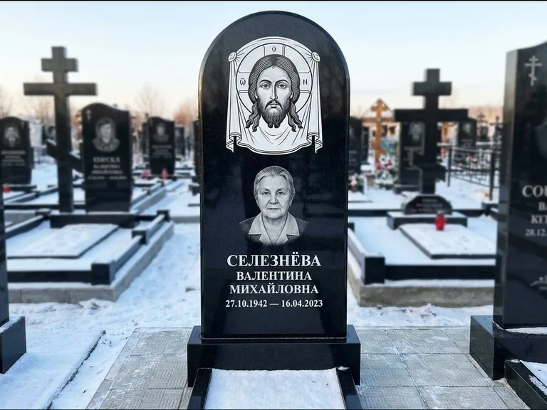 Памятник с гравировкой иконы: небольшая скромная одиночная стела с именной иконой — золочёный нимб на образе, аккуратный участок с газоном, работа «Ковалёв» в Краснодаре