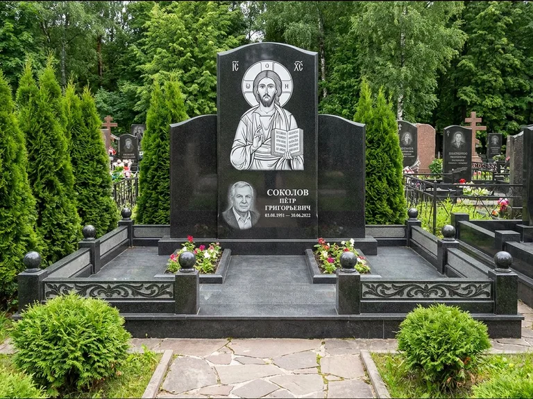 Памятник с гравировкой иконы: широкая горизонтальная лежачая плита-стела — икона в резной рамке-киоте, серая гравийная отсыпка с бордюром, работа «Богданова» в Краснодаре