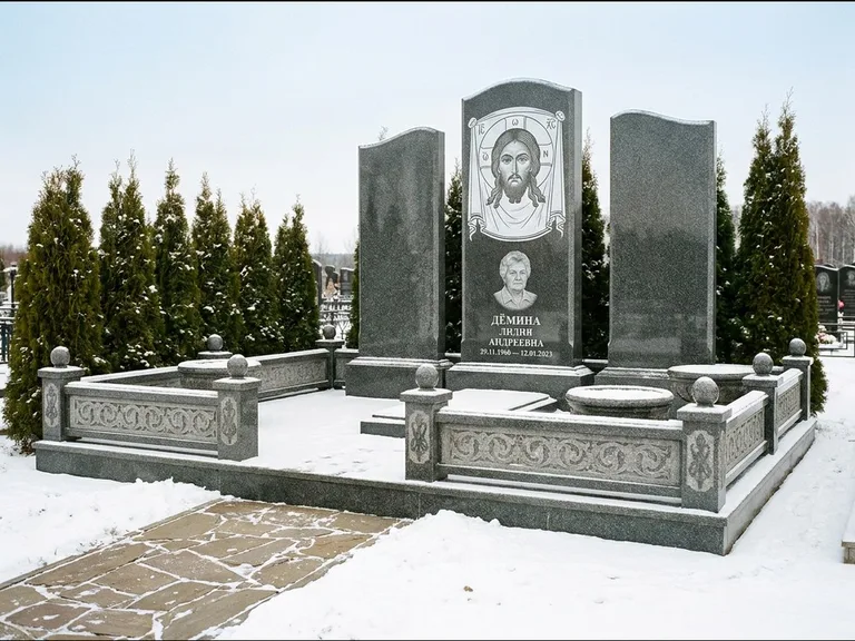 Памятник с гравировкой иконы: узкая вертикальная стела-пилон с ликом — икона в резной рамке-киоте, открытая лужайка без ограды, работа «Одинцов» в Краснодаре