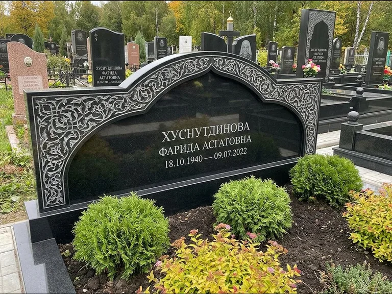 Мусульманский памятник: вытянутая горизонтальная семейная стела с аркой — белая гравировка силуэта мечети с минаретами, участок с декоративными кустами, работа «Зарипова» в Краснодаре