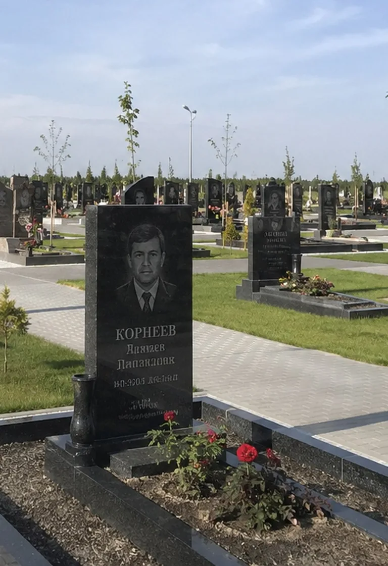 Современная гранитная стела на свежем участке Нового городского кладбища