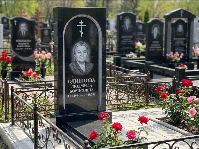 Памятник из чёрного гранита — скромная невысокая стела с крестом с терновым венцом, работа «Лаврентьева» в Краснодаре